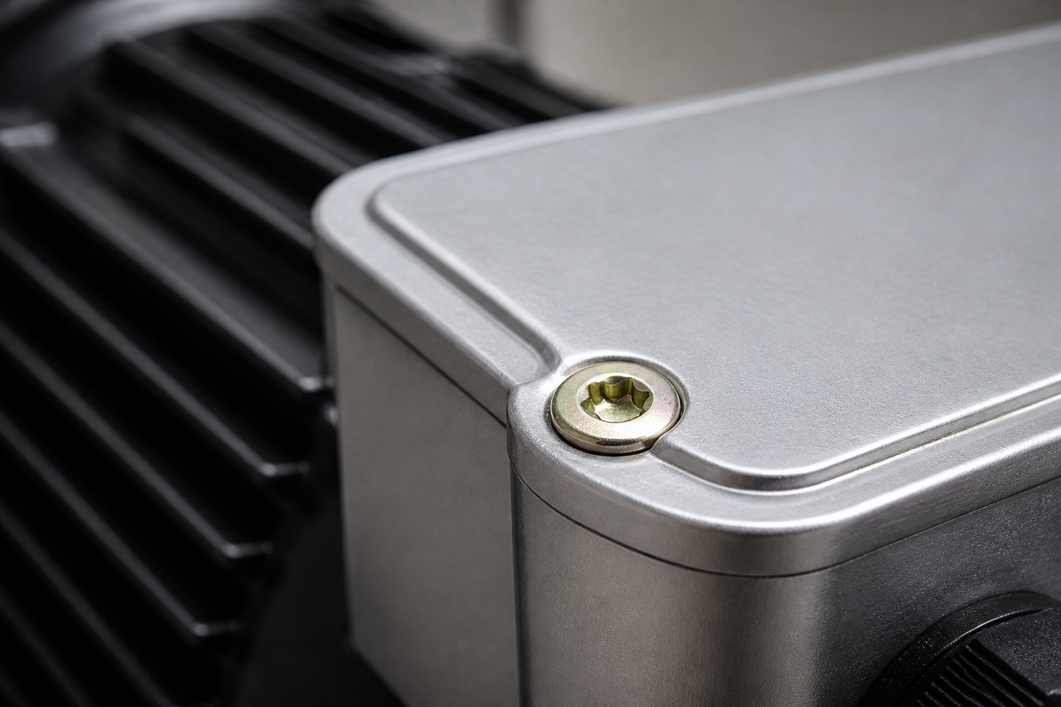 Motor terminal box — the Torx head seats on the machined cover and the shoulder step locates the lid before the thread engages.
