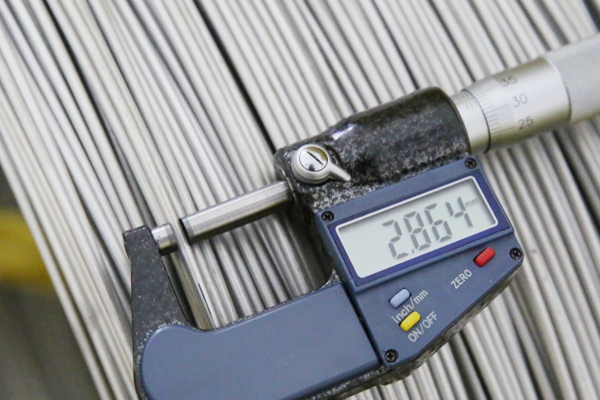 Carbon steel bar stock checked with a micrometer before a turned part run