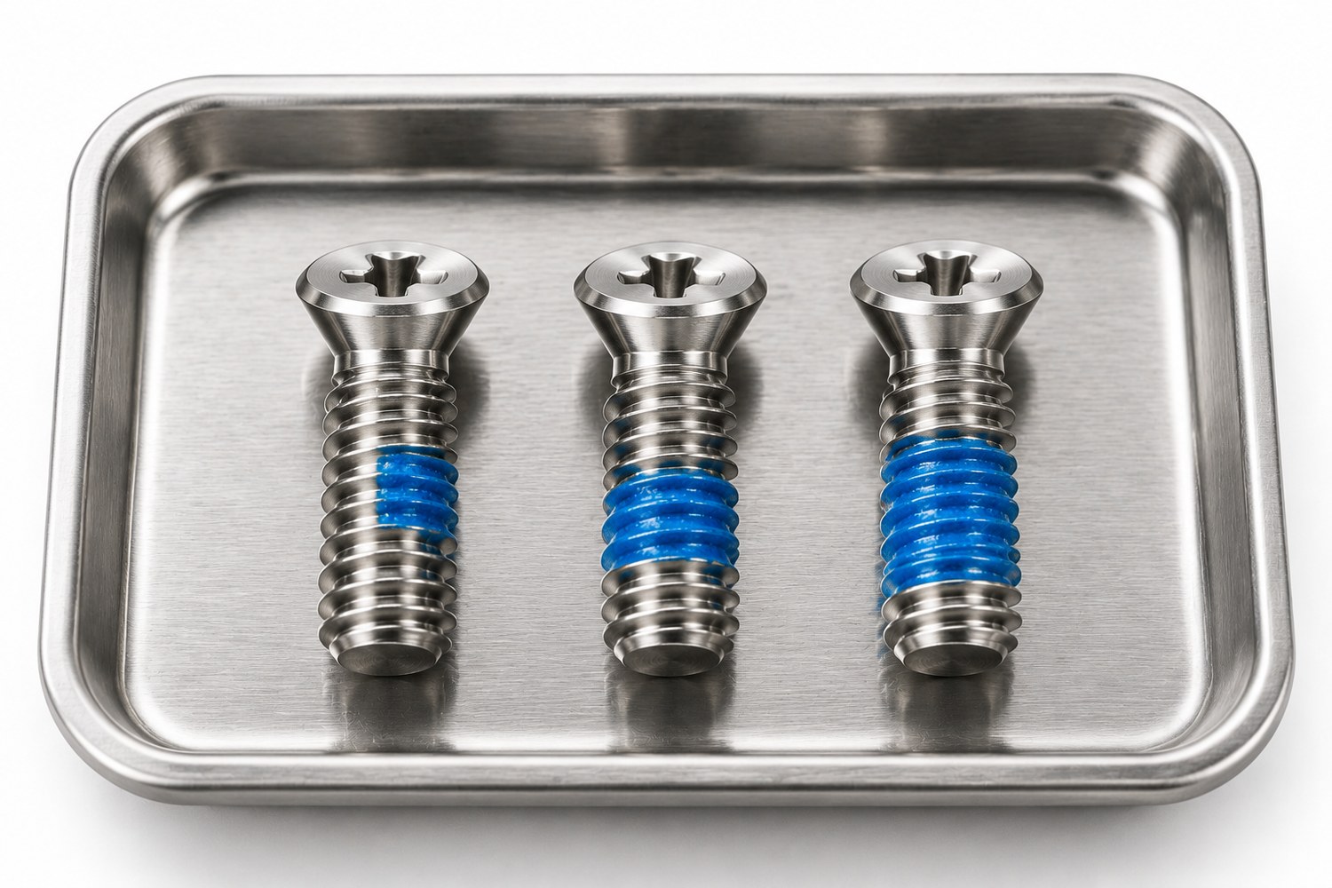Row of small stainless screws showing 90 degree, 180 degree and 360 degree locking patch coverage on the thread